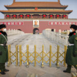 Paramilitary police wear face masks as they stand guard at Tiananmen Gate adjacent to Tiananmen Square in Beijing, Monday, Jan. 27, 2020. China on Monday expanded sweeping efforts to contain a viral disease by postponing the end of this week's Lunar New Year holiday to keep the public at home and avoid spreading infection. (AP Photo/Mark Schiefelbein)